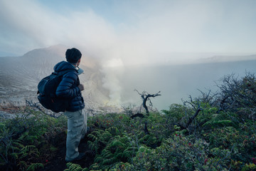 A traveler looking at the acid lake at the top Kawah Ijen in Java, Indonesia.