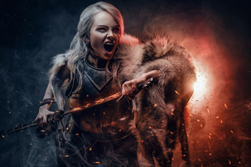 Fantasy woman wearing cuirass and fur, holding a sword and rushes into battle with a furious cry....