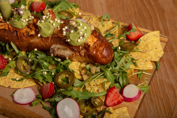 Naklejka na ściany i meble Brunch. First flat sandwich filled with chicken mix, pico de gallo, tortilla chips, guacamole, arugula, strawberries, radishes and nachos on a wooden board.