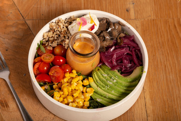 Salad with organic products of cherry tomatoes, corn, avocado, beets and quinoa. Healthy food.