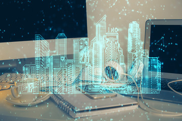 Desktop computer background in office and big town buildings hologram drawing. Double exposure. Smart city concept.