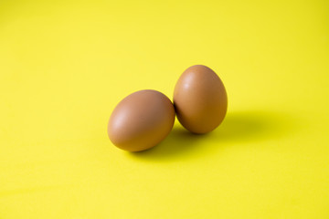 Chicken eggs are laid on yelow table