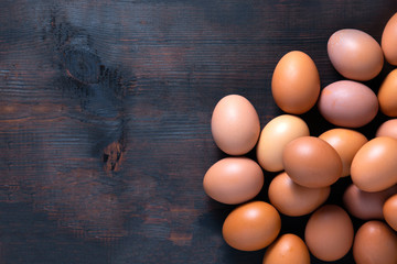 Chicken eggs lay on oak colored wooden tables copy space.