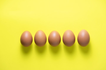 Chicken eggs are laid on yelow table
