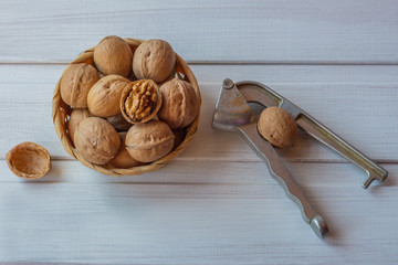 walnuts and nutcracker on a white wooden background