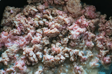 Fried minced meat in a frying pan.  Cooking minced meat  on frying pan.