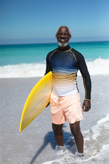 Old man carrying a surfboard