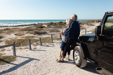 Fototapeta premium Old couple with a car at the beach