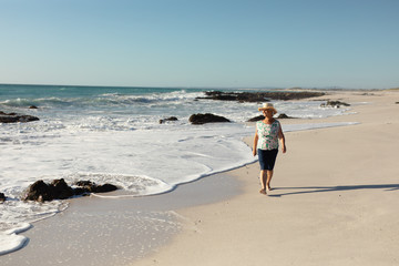 Old woman walking at the beach