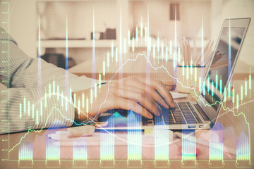 Double exposure of stock market graph with man working on laptop on background. Concept of financial analysis.