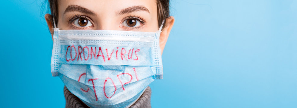 Portrait of a woman in medical mask with stop coronavirus text at blue background. Coronavirus concept. Respiratory protection