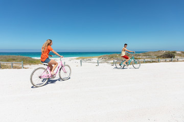 Fototapeta premium Young couple with bikes at the beach