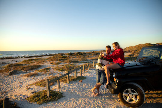 Couple with car at the beach