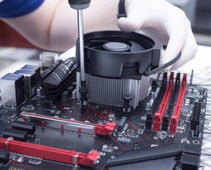 Hands of a technician assembling computer hardware parts new cpu is being mounted unto the...