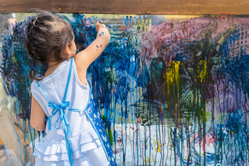 Cute Little Girl Is Painting On Glass outdoor.