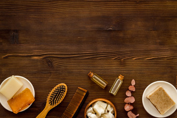 Hair care concept. Coconut oil, brush on dark wooden background top-down frame copy space