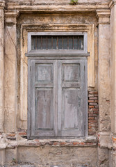 Fototapeta na wymiar Old window on abandoned building's old brick wall 