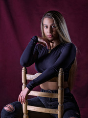 Portrait of a teenage girl, sitting on a chair, looking at the camera