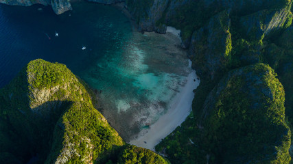 Aerial drone view of iconic tropical turquoise water Maya Bay surrounded by limestone cliffs, Phi Phi islands, Thailand