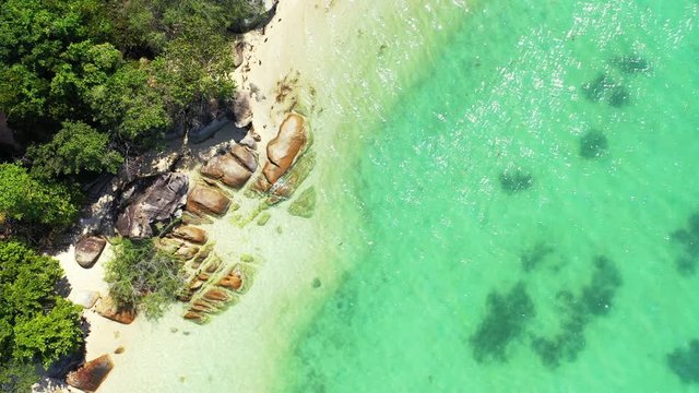 Crystal emerald water of turquoise lagoon caving beautiful limestone cliffs on shore of tropical island with lush vegetation, Ko Tao, Thailand