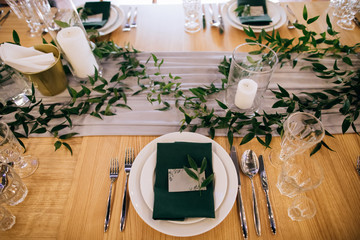 Lovely dining set for dinner at a restaurant. Decorating with green branches. Ideas for wedding.