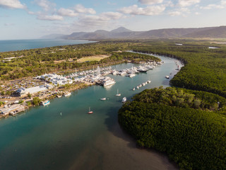 Marina town with waterfront river view of yachts and boats in sea water. Carins Port Douglas aerial...