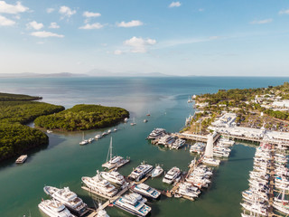 Marina town with waterfront river view of yachts and boats in sea water. Carins Port Douglas aerial...