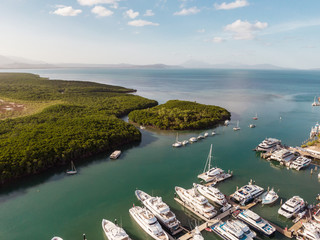 Marina town with waterfront river view of yachts and boats in sea water. Carins Port Douglas aerial...