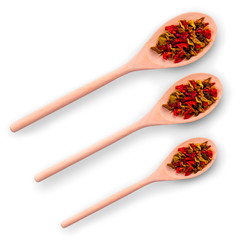 three wooden spoons with spices on a white background