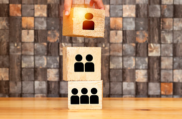 organization and team structure symbolized with big cubes, woman  hand placing piece of leathership...
