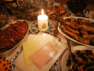 Lithuanian Christmas Eve table with Christmas wafers, candle and various dishes