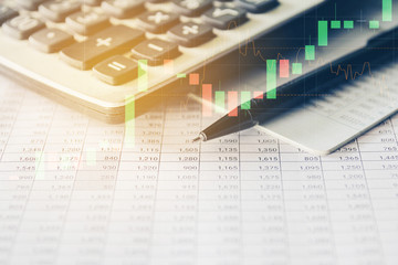 Pen and Calculator on accounting report with trading graph, Business and Financial concept. 
