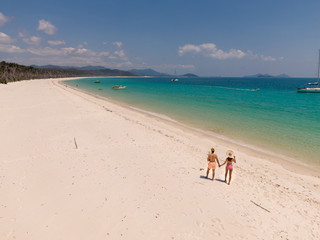 Couple on honeymoon on beach. Whitsundays aerial view, with turquoise ocean, white sand. Dramatic DRONE view from above. Travel, holiday, vacation, paradise. Shot in Whitsundays Islands, Queenstown, A