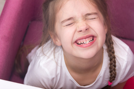 Little girl shows her teeth. Baby teeth concept.