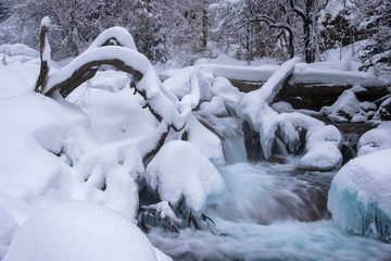 Moutain river covered with snow in winter time. Winter landscape beauty. Scenic wild nature. Cold weather.