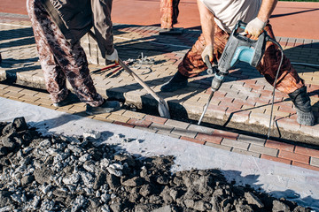 Workers laid paving slabs. Two workers lay paving slabs.