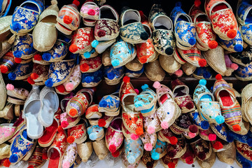 A lot of colorful shoes on the market. View of shoes on the market.