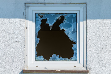Broken window in a  building. The concept of vandalism