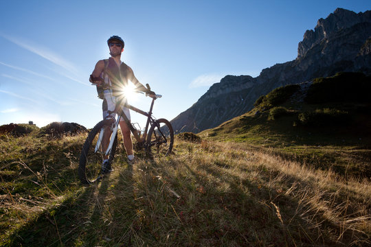moutain biking in the austrian alps during sunset
