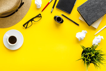 Writer's block concept. Notebook, pen, crumpled paper on yellow background top-down frame copy space