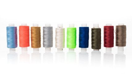 tailor needles and threads over white background