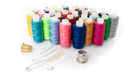 tailor needles and threads over white background
