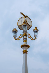 Fototapeta na wymiar Classic style streeet clock. Street retro clock with a bird on sky background.