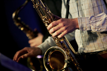 Hands of tenor saxophone player on the stage