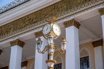 Classic style streeet clock. Street retro clock with a bird on sky background.
