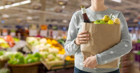 shopping, healthy eating and eco friendly concept - close up of woman with paper bag full of food...