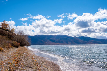 View on Markakol lake with mountains and cloudy sky  background. Mountain lake in autumn.