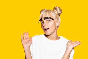 Portrait of joyful pretty female having fun with fake giant makeup. 