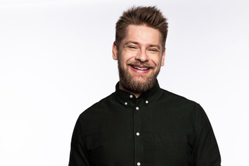 Handsome bearded guy looking at camera and smiling on white background.