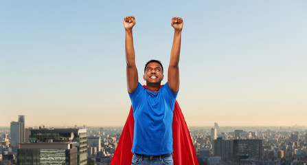 Fototapeta na wymiar super power and people concept - indian man in red superhero cape flying over tokyo city background